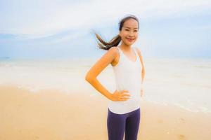 retrato bela jovem esporte mulher asiática exercício correndo e correndo na praia e no mar ao ar livre foto