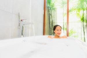 retrato jovem linda mulher asiática tomando banho na banheira foto