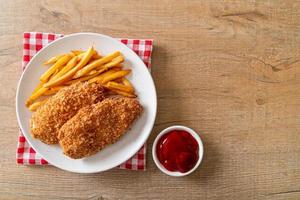 Filé de peito de frango frito com batata frita e ketchup foto