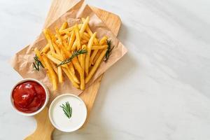 batatas fritas com creme de leite e ketchup foto