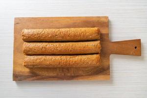 bolo de peixe chinês frito ou linha de bola de peixe na placa de madeira foto