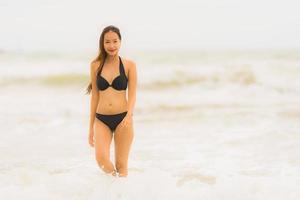 retrato linda jovem asiática usar biquíni na praia, mar, oceano foto