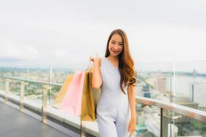 retrato linda jovem asiática feliz e sorrindo com a sacola de compras da loja de departamentos foto