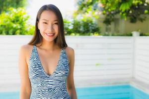 retrato linda jovem asiática feliz sorrindo relaxando na piscina ao ar livre foto