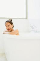retrato bela jovem asiática tomar uma banheira no banheiro foto