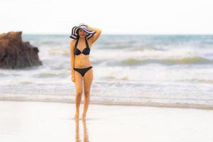 retrato linda jovem asiática usar biquíni na praia, mar, oceano foto