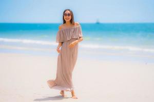 retrato linda jovem mulher asiática feliz sorriso relaxar na praia tropical, mar, oceano foto