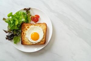 pão caseiro torrado com queijo e ovo frito por cima com salada de legumes no café da manhã