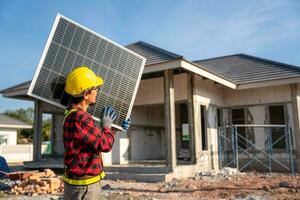 ásia técnicos vestindo segurança roupas levar solar células para instalar em a cobertura do uma casa às construção local. conceito do alternativo e renovável energia. foto