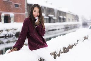 bela jovem asiática sorrindo e feliz com a viagem de viagem no canal otaru hokkaido no japão foto