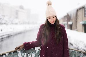 bela jovem asiática sorrindo e feliz com a viagem de viagem no canal otaru hokkaido no japão foto