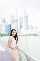 linda mulher asiática sorrindo e feliz por viajar na cidade de Singapura foto