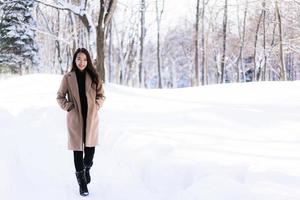 retrato jovem linda mulher asiática sorrir feliz viajar e desfrutar com neve inverno temporada foto