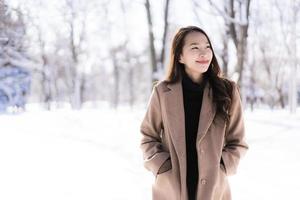 retrato jovem linda mulher asiática sorrir feliz viajar e desfrutar com neve inverno temporada foto