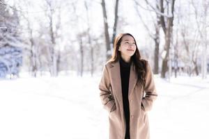 retrato jovem linda mulher asiática sorrir feliz viajar e desfrutar com neve inverno temporada foto