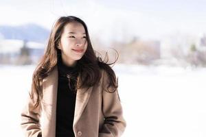 retrato jovem linda mulher asiática sorrir feliz viajar e desfrutar com neve inverno temporada foto