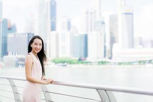 linda mulher asiática sorrindo e feliz por viajar na cidade de Singapura foto