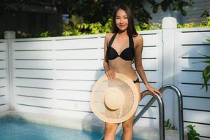 retrato linda jovem asiática feliz sorrindo relaxando na piscina ao ar livre foto