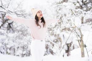 retrato jovem linda mulher asiática sorrir feliz viajar e desfrutar com neve inverno temporada foto