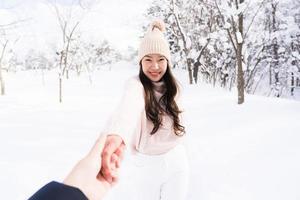 retrato jovem linda mulher asiática sorrir feliz viajar e desfrutar com neve inverno temporada foto