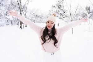 retrato jovem linda mulher asiática sorrir feliz viajar e desfrutar com neve inverno temporada foto