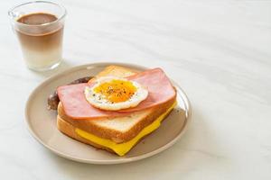 pão caseiro queijo torrado com presunto coberto e ovo frito com linguiça de porco no café da manhã foto