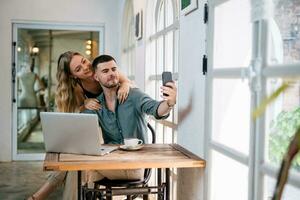 feliz casal levando selfie enquanto escolhendo projeto em computador portátil. pessoas e moderno tecnologia conceito. foto