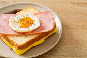 pão caseiro queijo torrado, presunto com cobertura e ovo frito com linguiça de porco no café da manhã