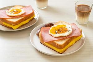 pão caseiro queijo torrado, presunto com cobertura e ovo frito com linguiça de porco no café da manhã