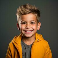 retrato do uma fofa pequeno Garoto dentro uma amarelo Jaqueta em uma cinzento fundo generativo ai foto