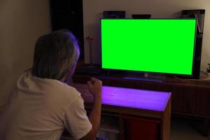 homem asiático assistindo televisão foto