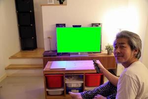 homem asiático assistindo televisão
