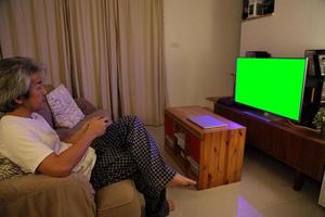 homem asiático assistindo televisão foto