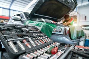 auto mecânico trabalhando dentro carro reparar estação. reparar serviço. selecionar foco equipamento ou chaves para carro reparos. foto