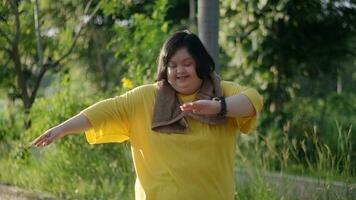 ásia menina com baixa síndrome exercício às a parque. foto