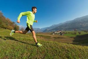 atleta corre ladeira abaixo no prado em um vale dos Alpes italianos. foto