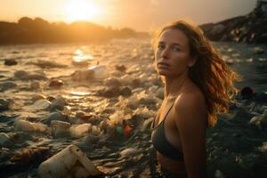 jovem mulher colecionar plástico desperdício dentro a mar às pôr do sol. de Meio Ambiente poluição conceito. foto