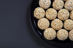 amaranth ladoo ou rajgira laddu ou cholai ke laddo em placa preta sobre fundo preto. foto