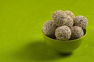 amaranto ou rajgira laddu, cholai ke laddo em tigela verde sobre fundo verde foto