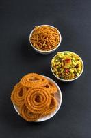 lanche indiano chakli, chakali ou murukku e besan grama farinha sev e chivada ou chiwada. comida diwali foto