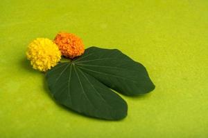 festival indiano dussehra, mostrando folhas douradas bauhinia racemosa e flores de calêndula em um fundo marrom.