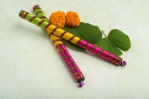 festival indiano dussehra, mostrando folhas douradas de bauhinia racemosa e flores de calêndula com paus de dandiya. foto