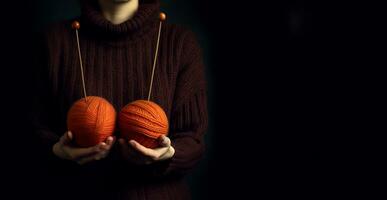 uma mulher dentro uma suéter segurando fio bolas em Preto fundo. foto