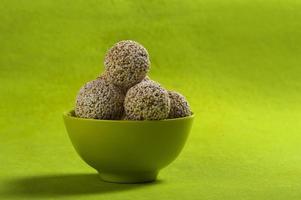 amaranto ou rajgira laddu, cholai ke laddo em tigela verde sobre fundo verde foto