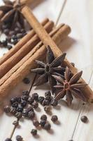 especiarias e ervas. alimentos e ingredientes da cozinha. paus de canela, estrelas de anis e pimenta preta em um fundo de madeira.