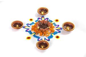 lâmpada diya de argila acesa durante o festival de diwali. argila diya em rangoli. feliz design de cartão de cumprimentos de diwali, festival de luzes hindu indiano chamado diwali. foto