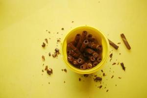 Rolo de bolacha sabor manga de chocolate em recipiente de plástico sobre fundo amarelo foto