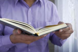 Mão de homem muçulmano segurando o livro sagrado Alcorão com espaço de cópia foto