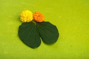 festival indiano dussehra, mostrando folhas douradas bauhinia racemosa e flores de calêndula em um fundo marrom.