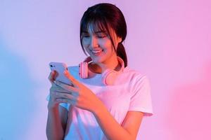 jovem asiática jogando no telefone com empolgação foto